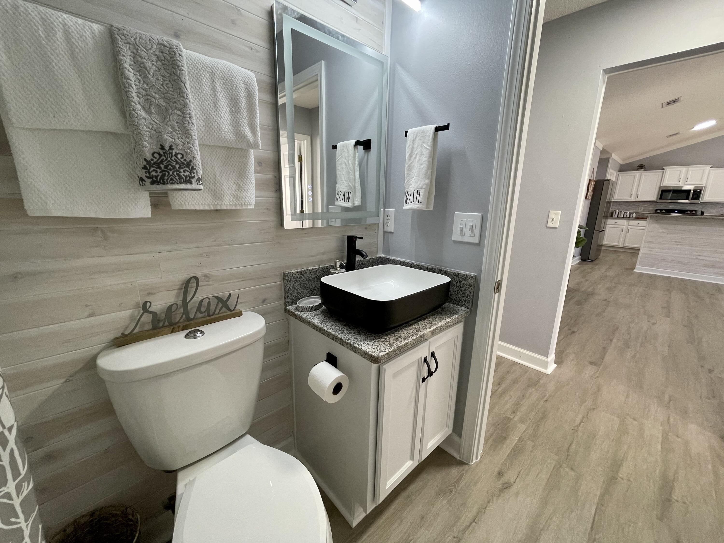 4694 Bobolink Way Crestview, FL 32539 - Photo 12 of 28 a bathroom with a granite countertop toilet sink and mirror