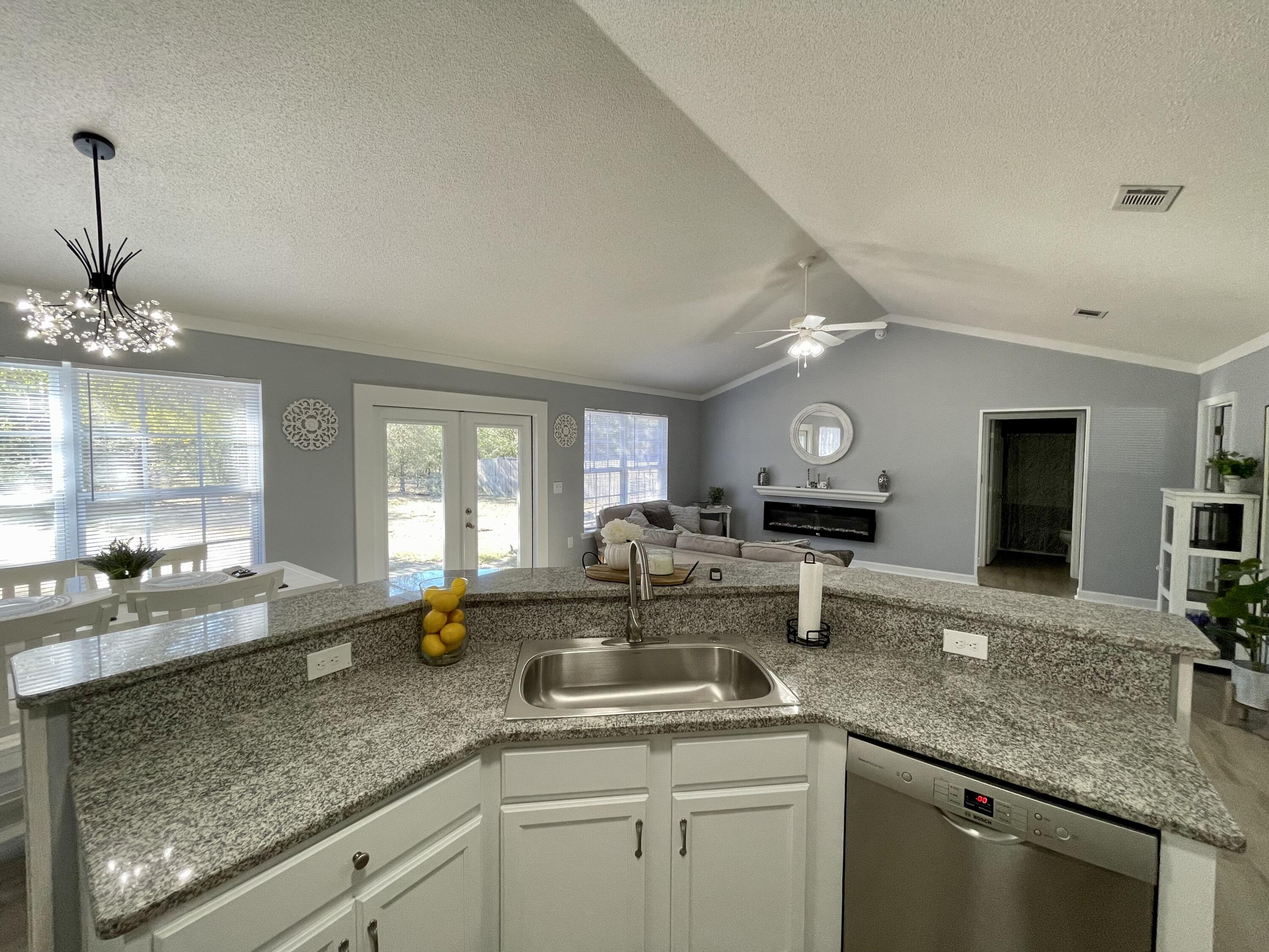 4694 Bobolink Way Crestview, FL 32539 - Photo 16 of 28 a kitchen with counter top space a sink and large window