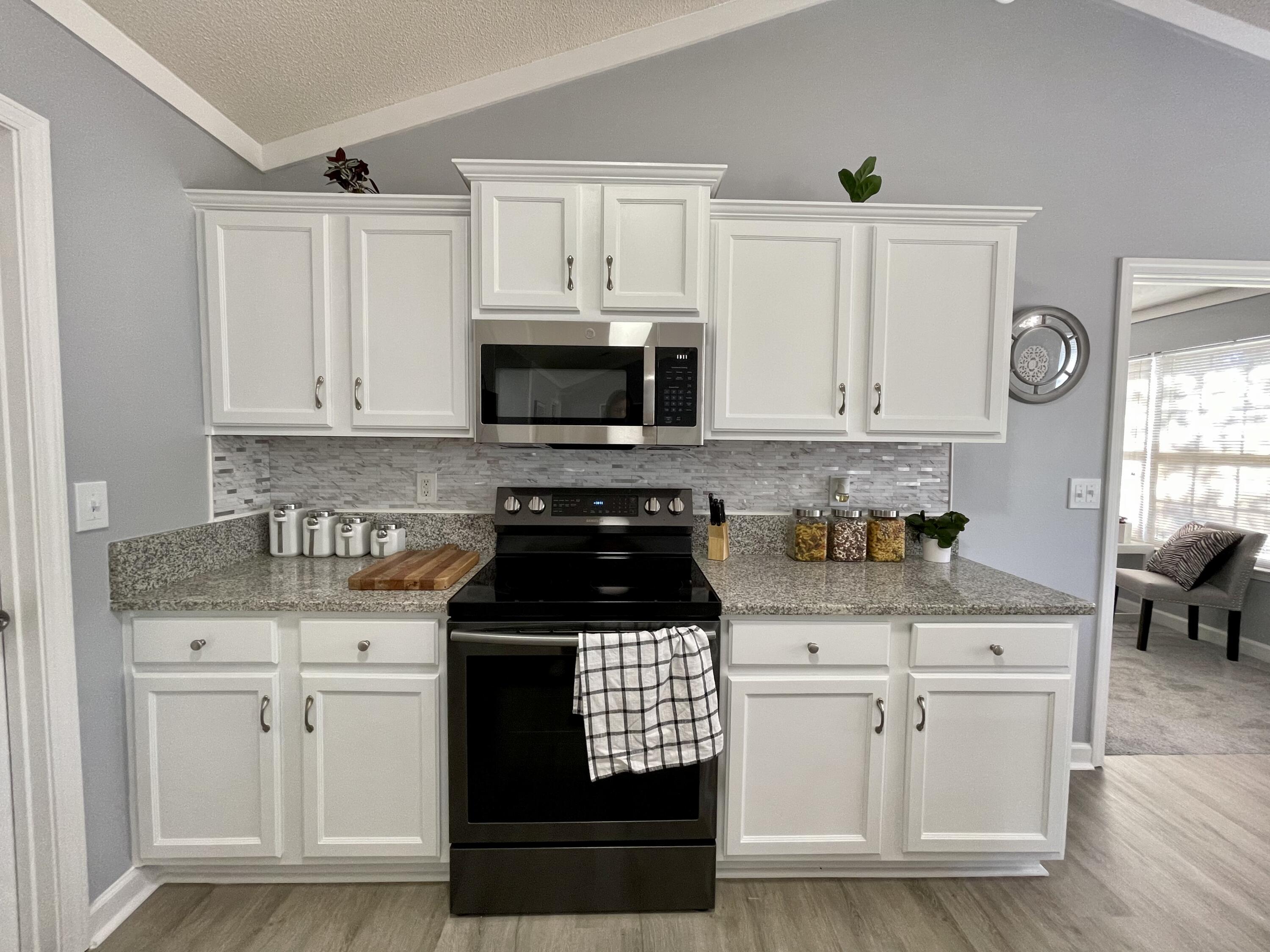 4694 Bobolink Way Crestview, FL 32539 - Photo 17 of 28 a kitchen with white cabinets and black appliances