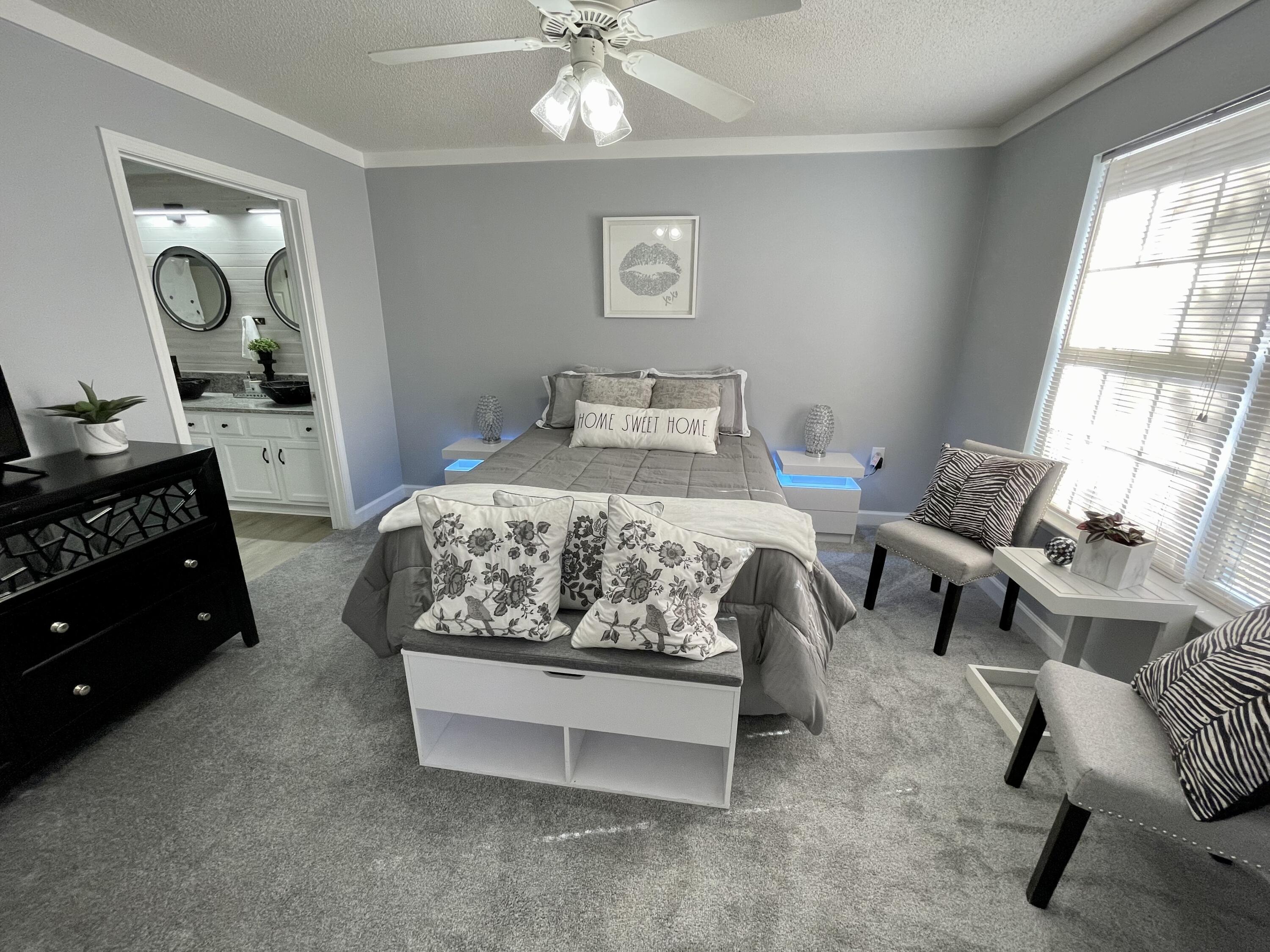 4694 Bobolink Way Crestview, FL 32539 - Photo 19 of 28 a bedroom with a bed and a chandelier