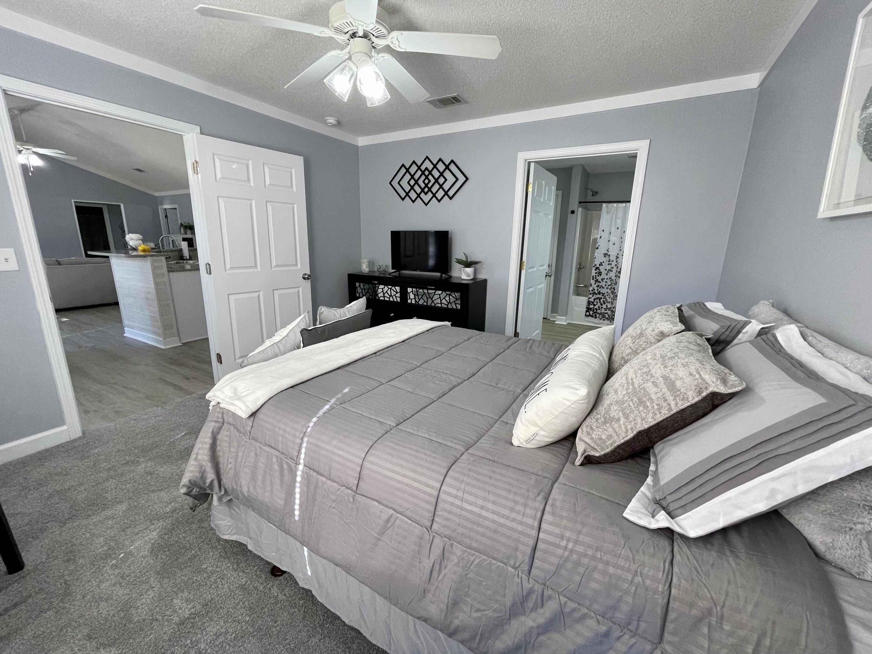 4694 Bobolink Way Crestview, FL 32539 - Photo 22 of 28 a bedroom with a large bed and a chandelier