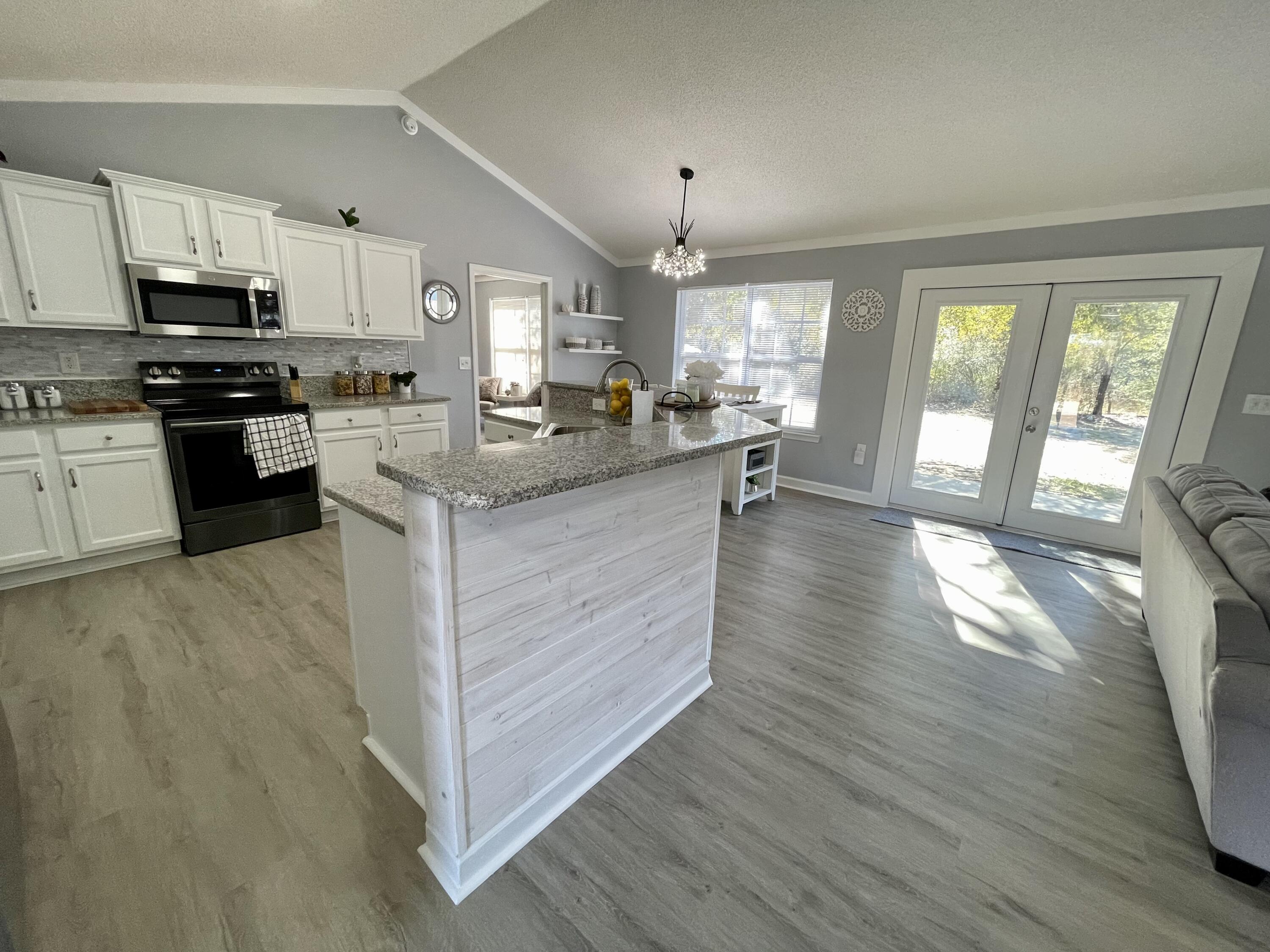 4694 Bobolink Way Crestview, FL 32539 - Photo 4 of 28 a kitchen with granite countertop a stove top oven and cabinets
