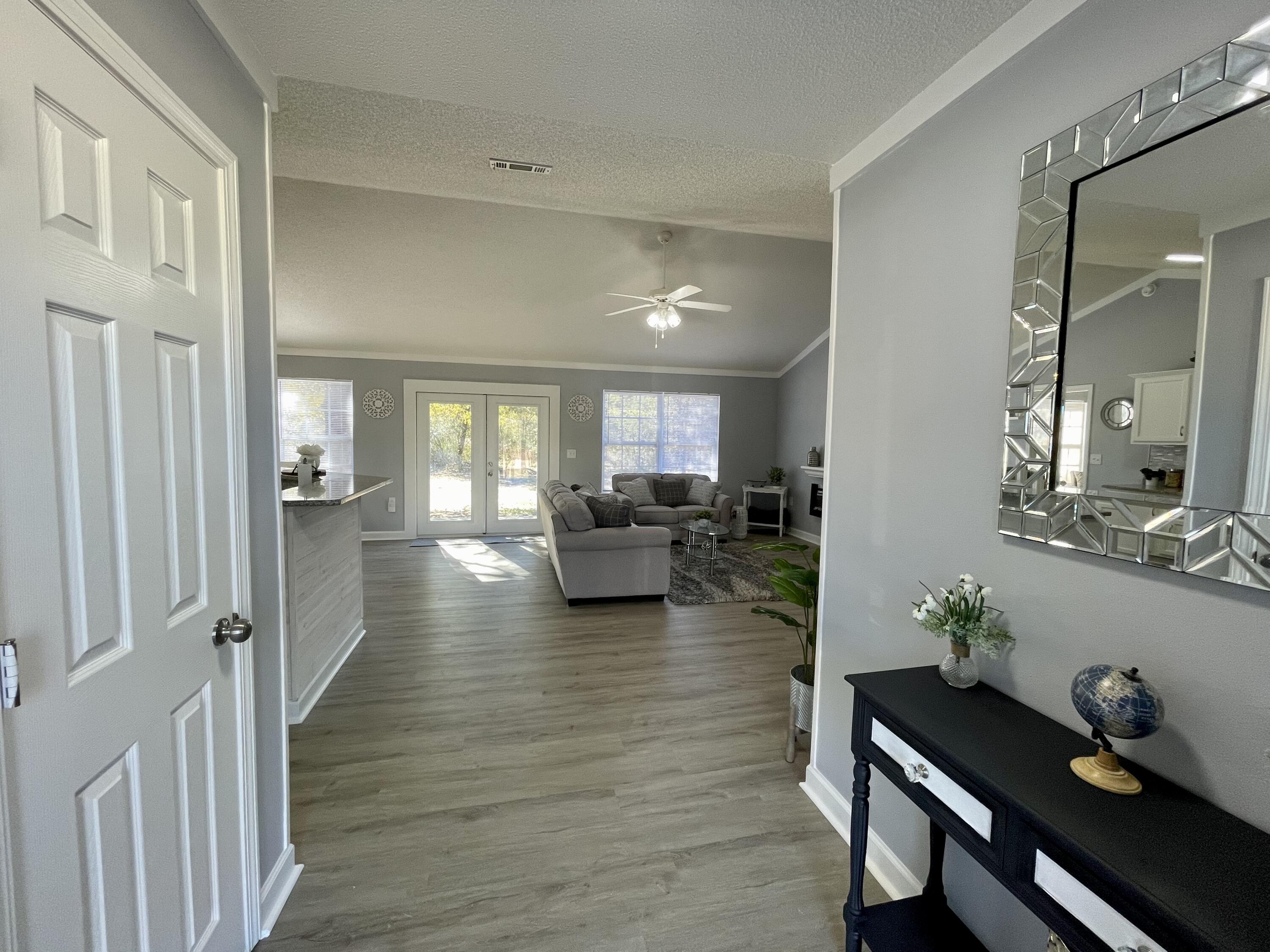 4694 Bobolink Way Crestview, FL 32539 - Photo 5 of 28 a hallway with wooden floor and furniture