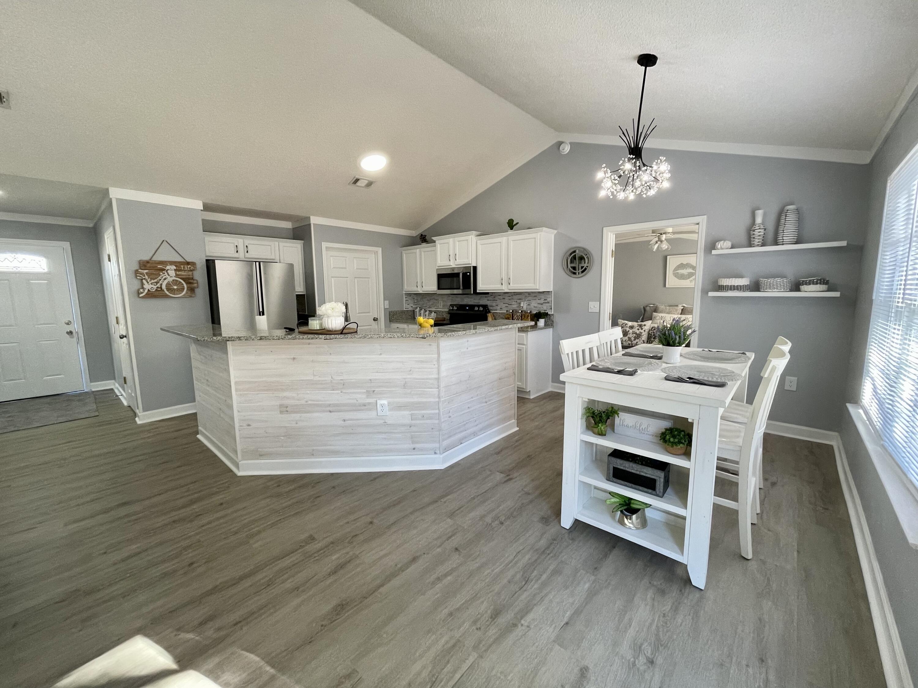 4694 Bobolink Way Crestview, FL 32539 - Photo 7 of 28 a large kitchen with kitchen island a large counter space a sink appliances and cabinets