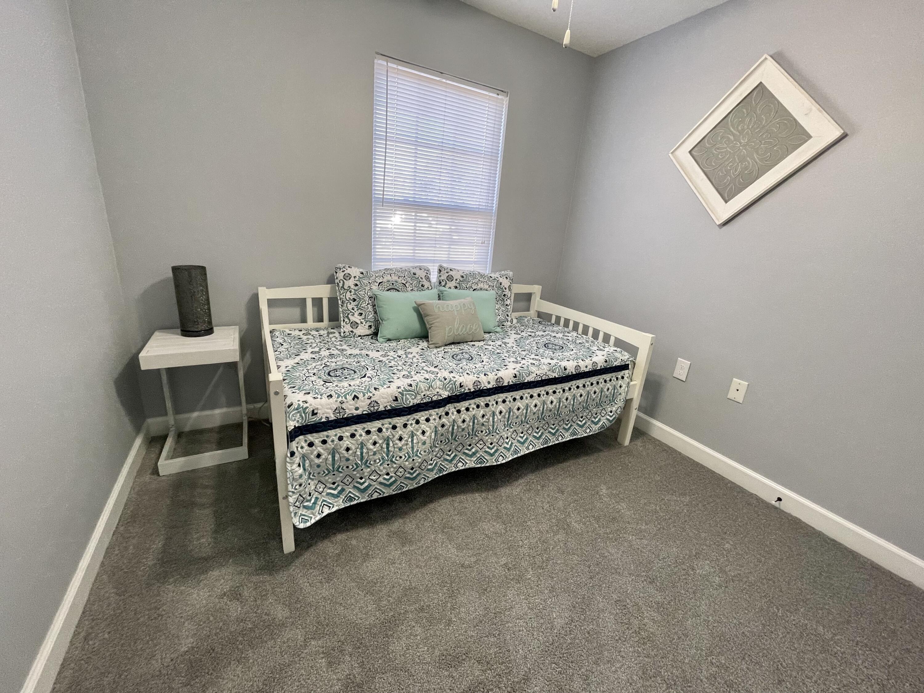 4694 Bobolink Way Crestview, FL 32539 - Photo 9 of 28 a bed sitting in a bedroom next to a window