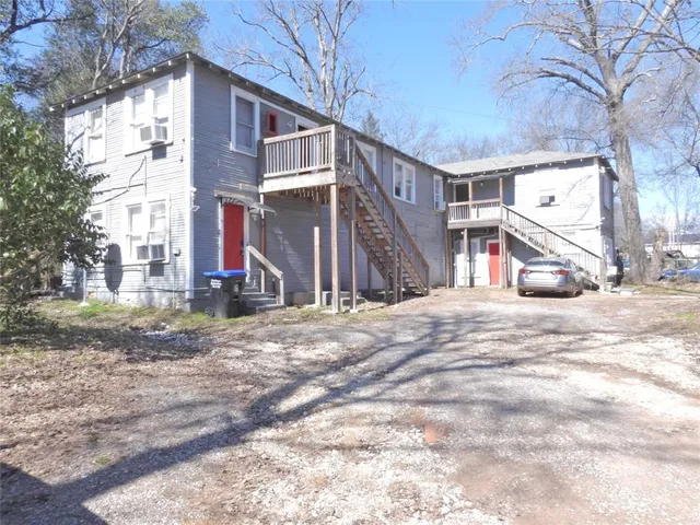 a view of a house with a yard and large tree