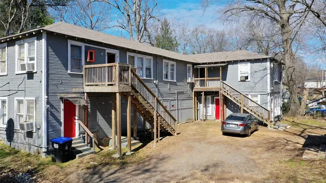 a view of a house with a tree in front of it