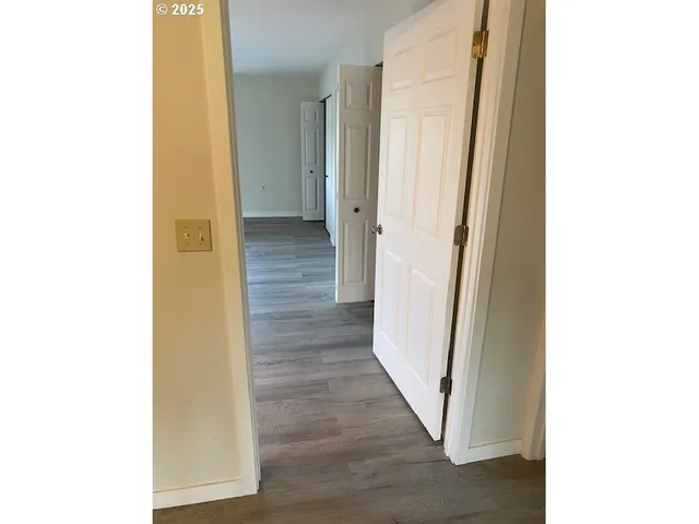 a view of a hallway with wooden floor