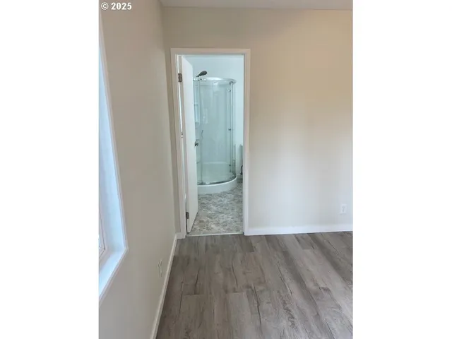 a view of a hallway with wooden floor