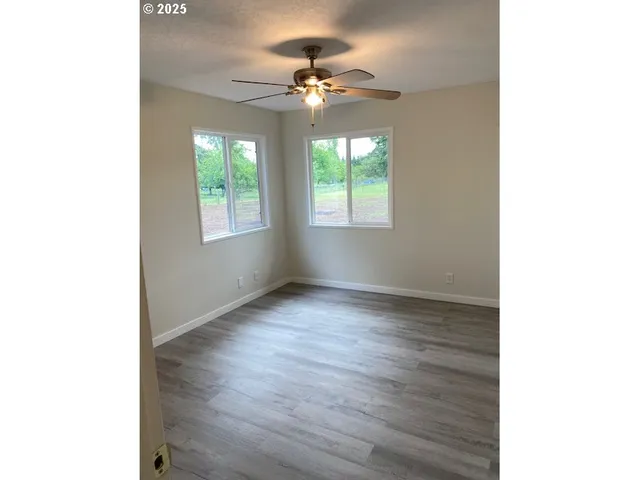 a view of a livingroom with a window and a ceiling fan