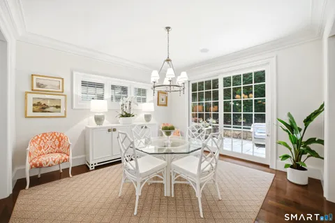 a dining room with furniture a chandelier and wooden floor