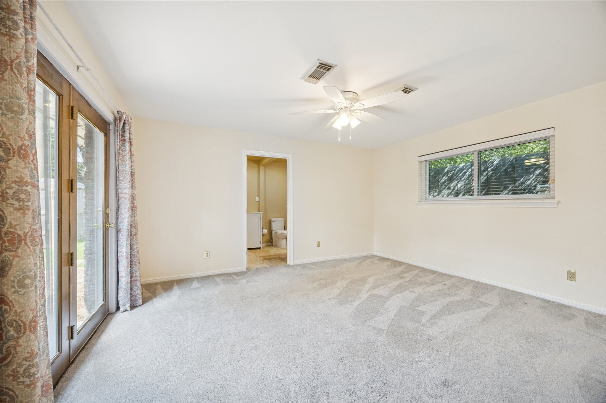 10050 Locke Lane Houston, TX 77042 - Photo 14 of 31 an empty room with chandelier fan and windows