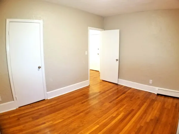a view of an empty room with wooden floor