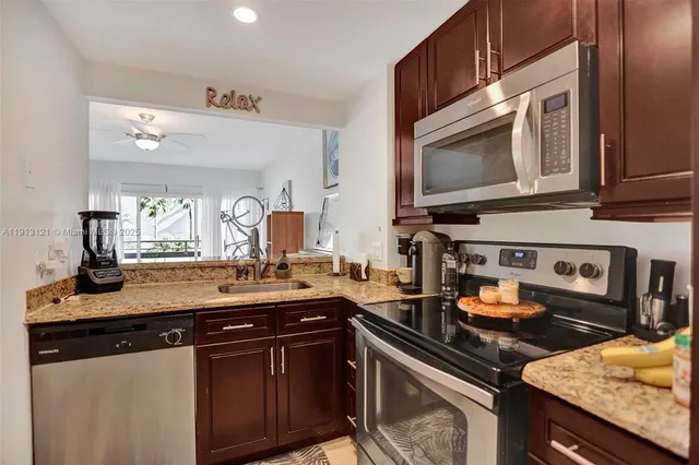 a kitchen with stainless steel appliances granite countertop a sink stove and microwave
