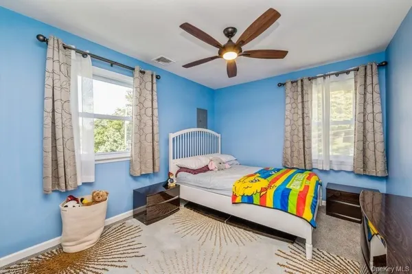 a bedroom with a bed a window and a chandelier