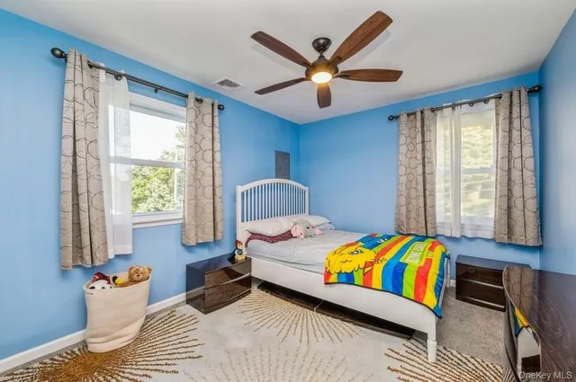 a bedroom with a bed a window and a chandelier