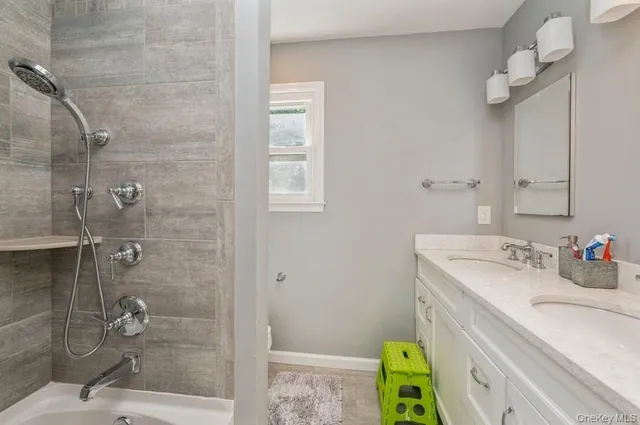 a bathroom with a sink mirror and shower