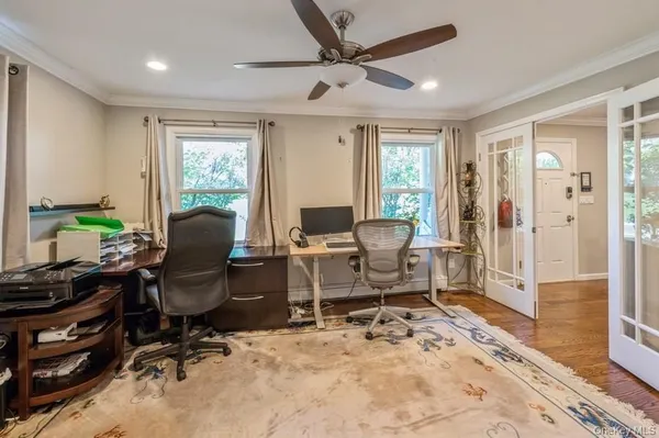 a view of a workspace with furniture and a window