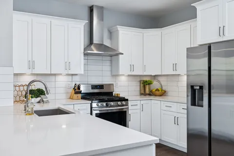a kitchen with stainless steel appliances a sink a stove a refrigerator a center island and cabinets