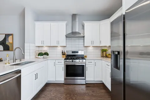 a kitchen with white cabinets and appliances