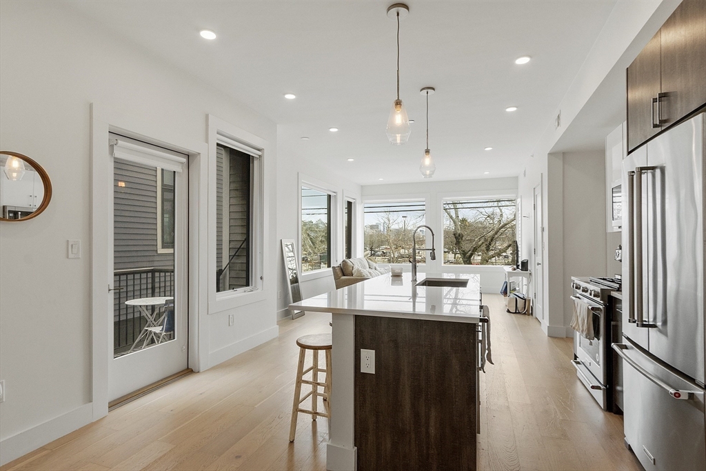 a very nice looking living room with a large window and stainless steel appliances