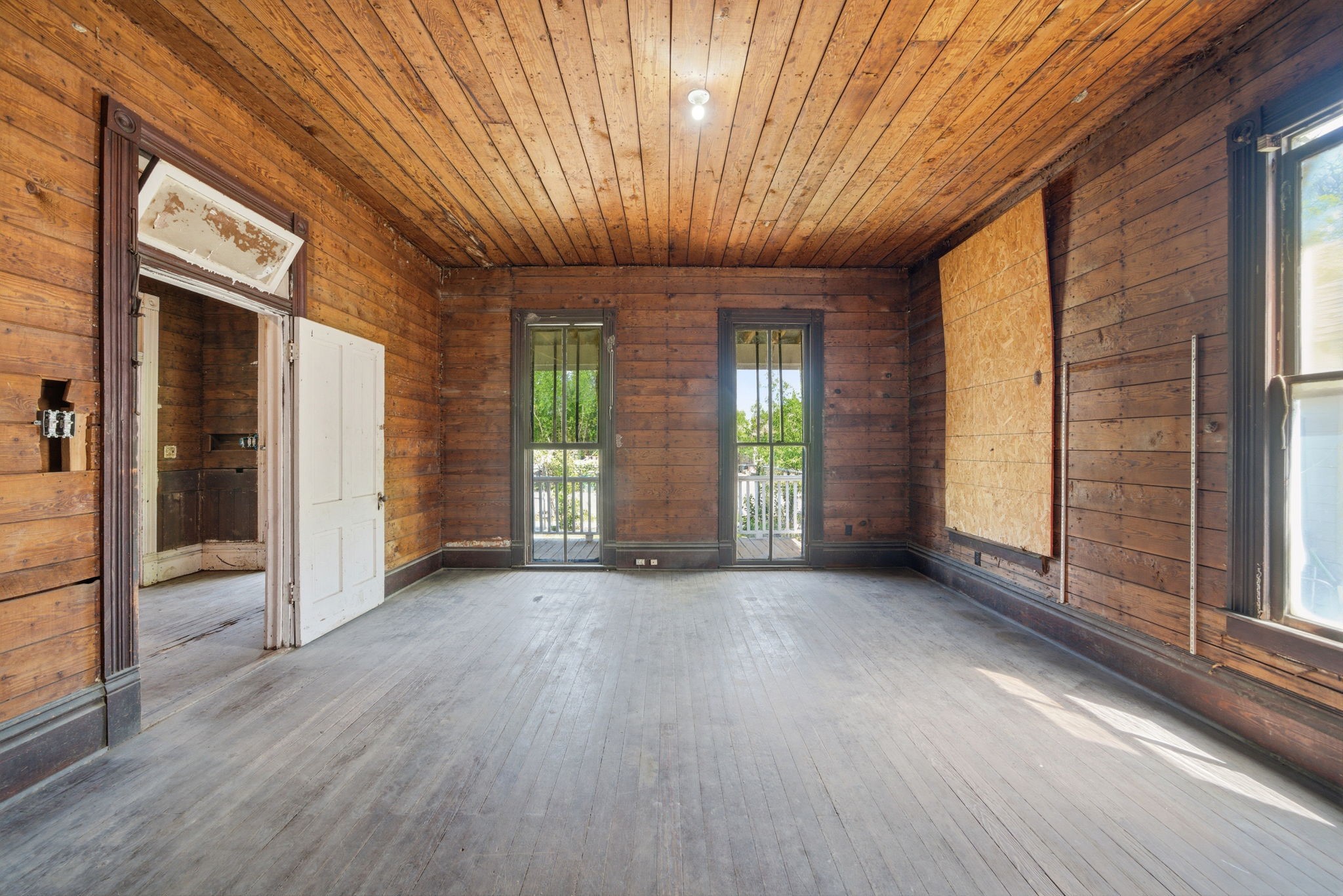 2023 Everett Street Houston, TX 77009 - Photo 11 of 25 Front room, behind the front porch. x2 JIB WINDOWS (floor to ceiling windows)!! Step through them onto the front porch!! This would make a FAB Living Room!! Note 2 other windows in the room - lots of natural light! And transom window above door!