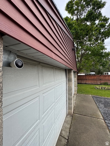 189 West Center Street Midvale, UT 84047 - Photo 60 of 64 White paneled garage door with block wall siding and red horizontal siding