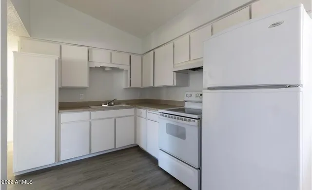 a kitchen with white cabinets and white appliances