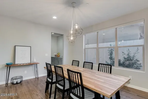 a large kitchen with cabinets chairs and wooden floor