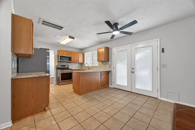 a kitchen with stainless steel appliances granite countertop a refrigerator and a stove top oven