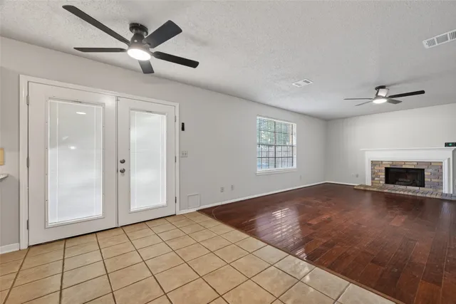 an empty room with windows and fireplace