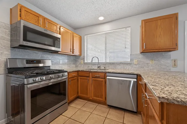 a kitchen with stainless steel appliances granite countertop a stove microwave and sink