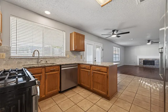 a kitchen with stainless steel appliances granite countertop a sink stove and cabinets