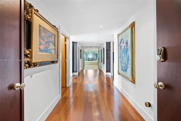 a living room with furniture floor to ceiling window and wooden floor