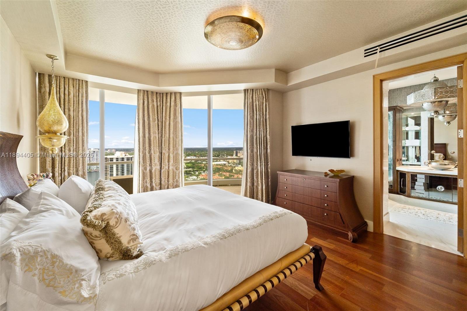 7000 Island Boulevard, Unit PH02 Aventura, FL 33160 - Photo 28 of 53 a bedroom with a bed and a flat tv screen on dresser