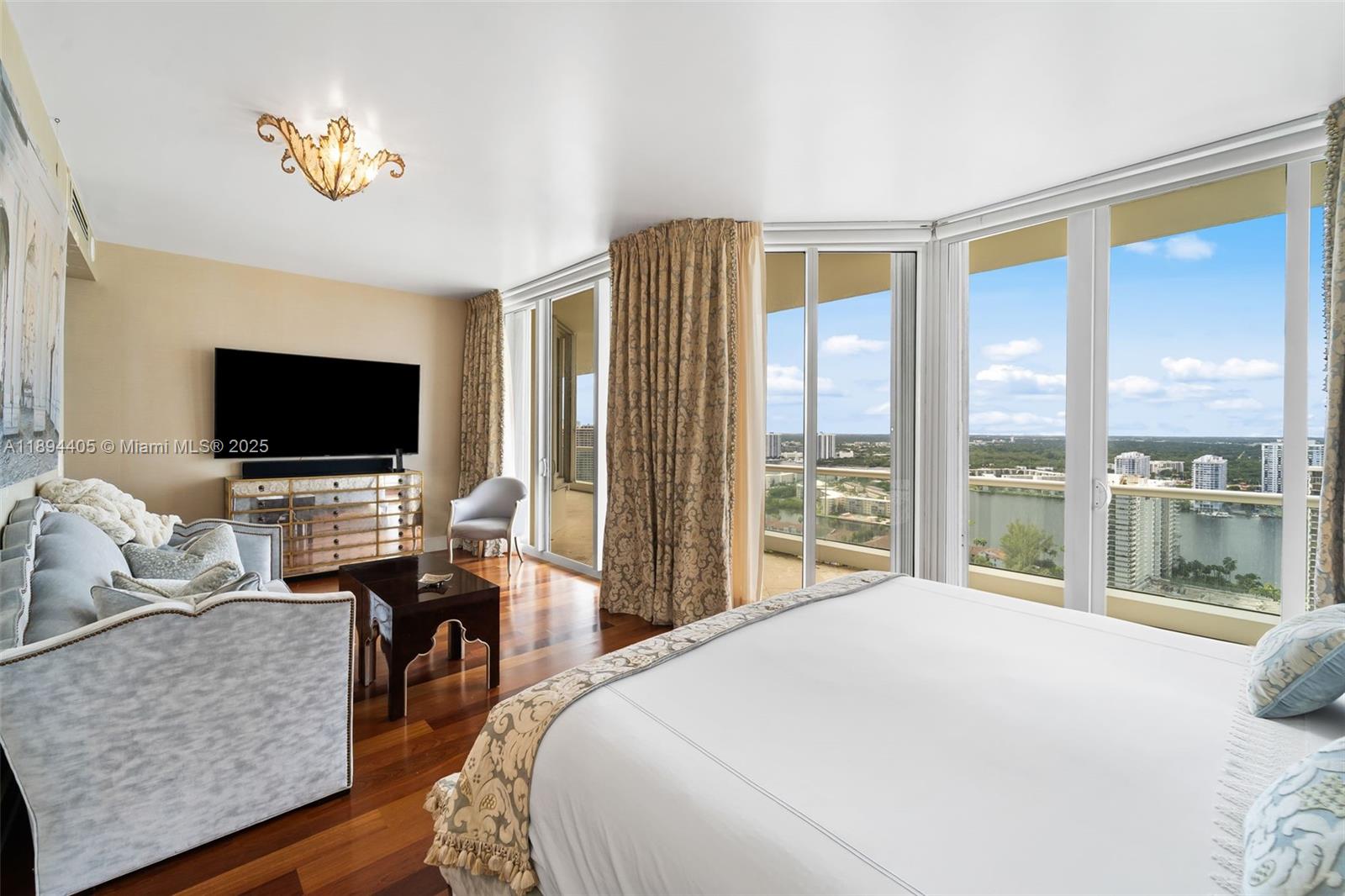 7000 Island Boulevard, Unit PH02 Aventura, FL 33160 - Photo 33 of 53 a bedroom with a bed and glass window