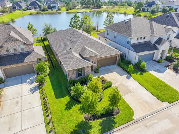 an aerial view of a house with a garden and lake view
