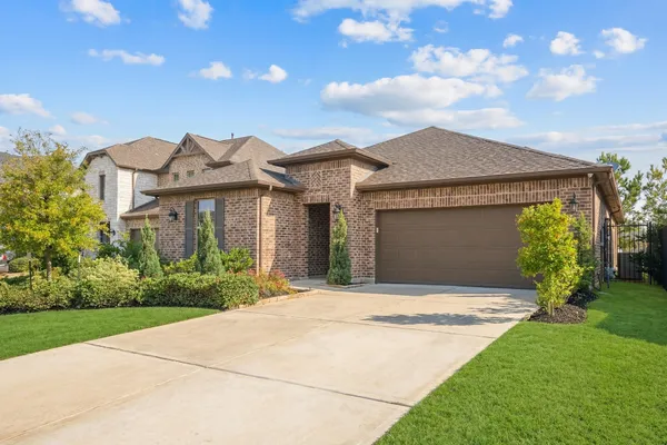 a front view of a house with a garden and plants