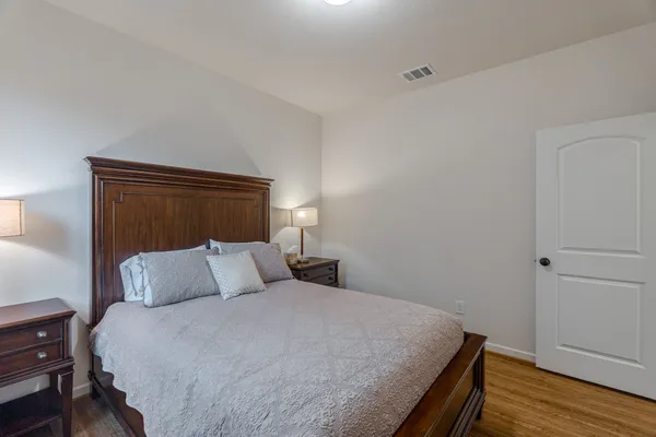 a bedroom with a bed and wooden floor