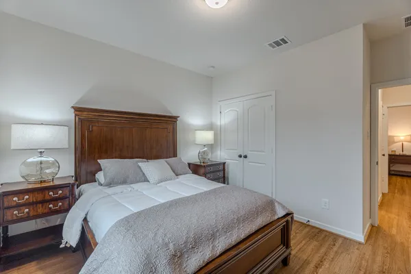 a bedroom with a bed and wooden floor
