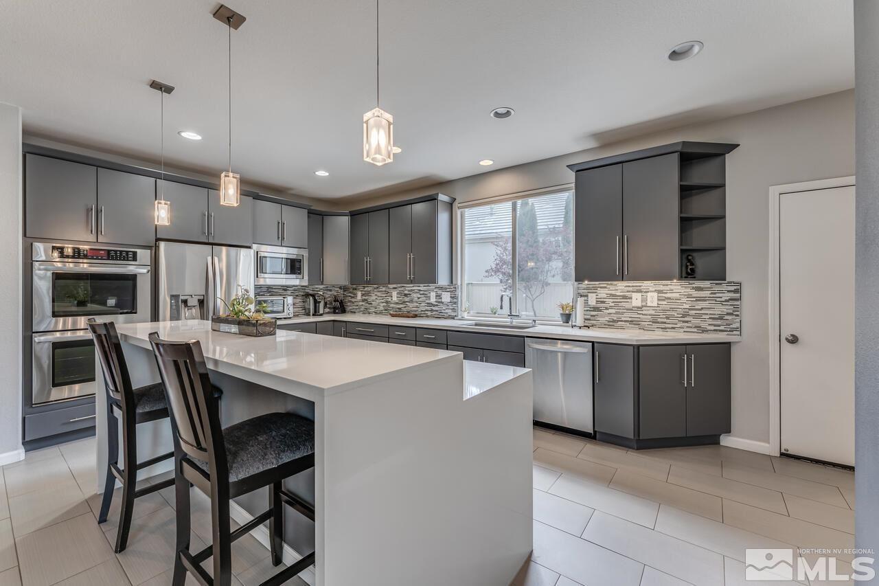 1735 Hunter Creek Road Reno, NV 89519 - Photo 7 of 30 a kitchen with kitchen island granite countertop wooden cabinets and white appliances