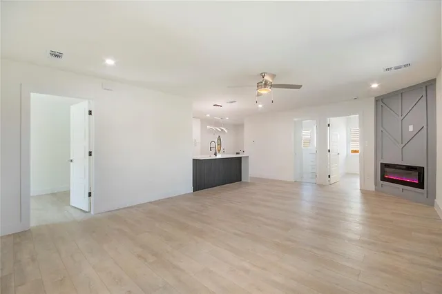 a view of a livingroom with wooden floor and a ceiling fan