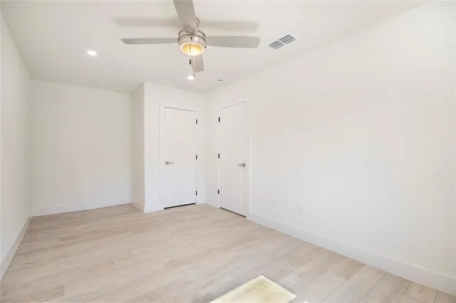 an empty room with a window and a ceiling fan