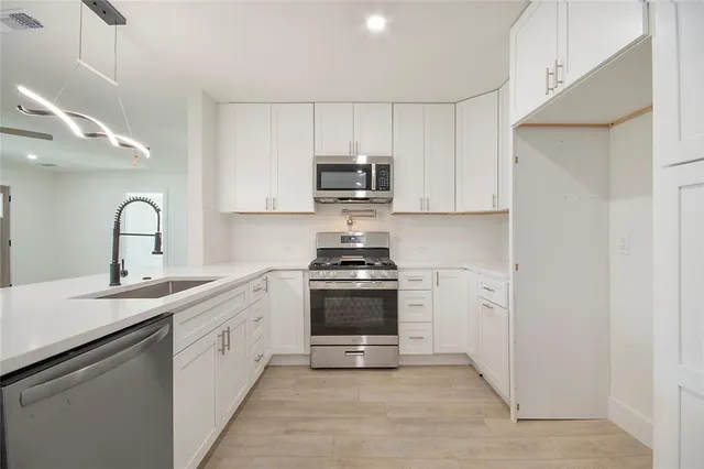 a kitchen with sink a stove and refrigerator