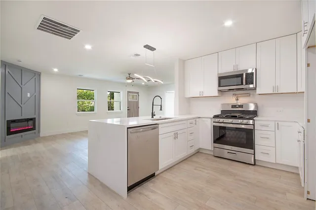 a kitchen with granite countertop a refrigerator and a stove top oven