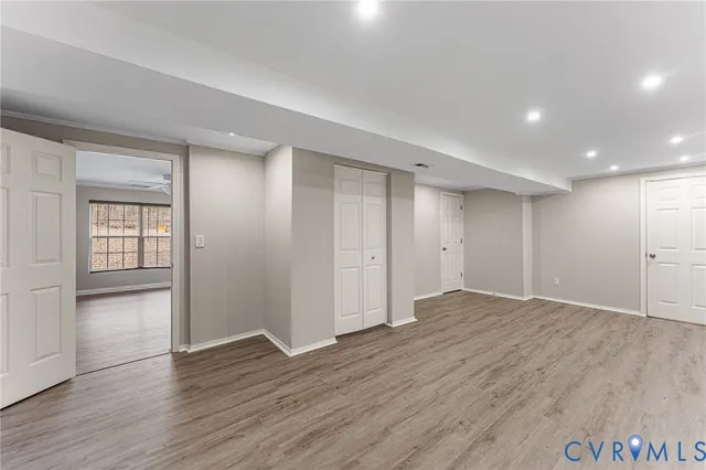 a view of an empty room with wooden floor and closet area