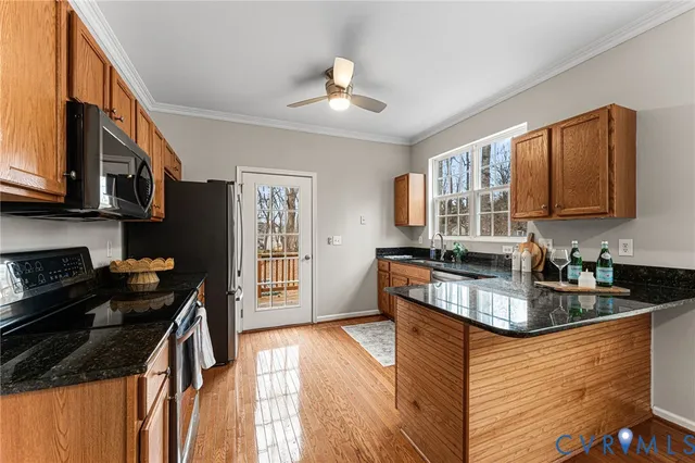 a kitchen with granite countertop a stove a sink dishwasher and a microwave oven with cabinets