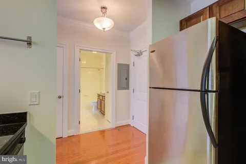 a view of a kitchen with a refrigerator and a stove top oven