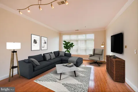 a living room with furniture a flat screen tv and a window