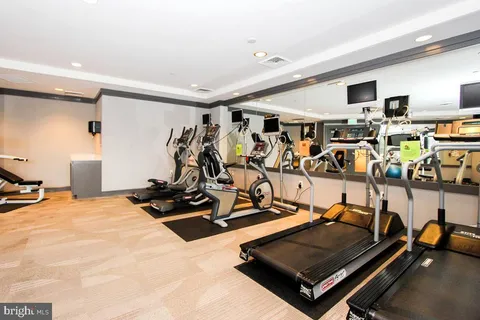 a room with gym equipment and mirror